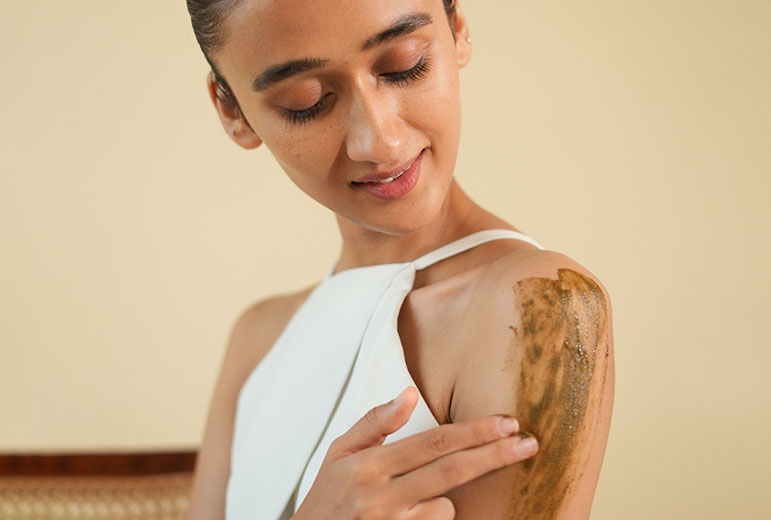 Woman applying skincare to her shoulder image on padma blog details page