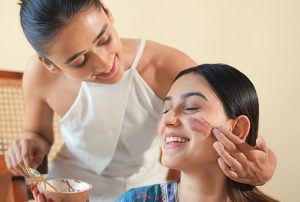 Two women applying facial masks, smiling image on padma home page